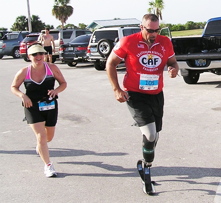 support4 woman and amputee man running in race