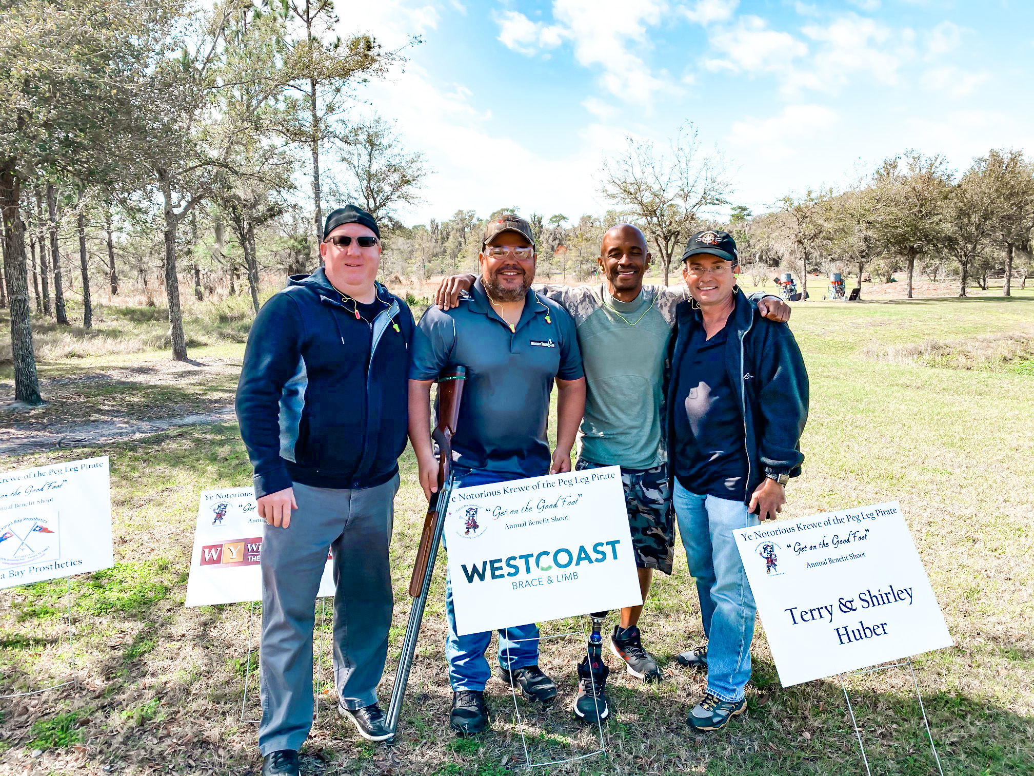 Peg Leg Pirates Clay Shoot – Without limits amputee support group Amputee Support Group - 4 men standing side by side in grass field at Clay Shoot